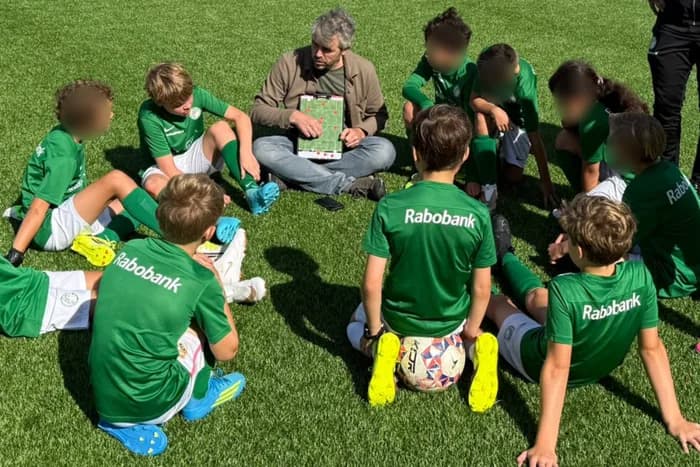 Een jeugdteam met trainer op het veld